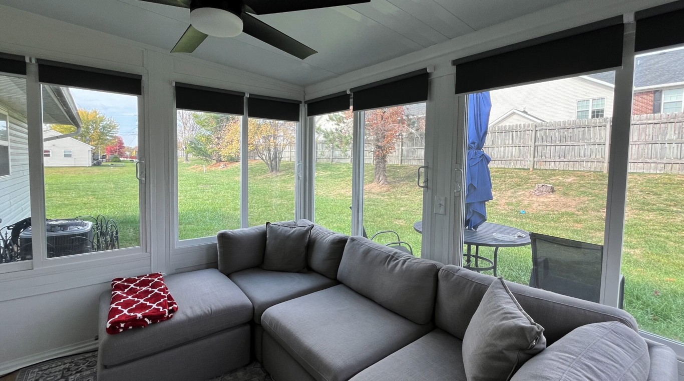 Four-season sunroom with climate control and gray sectional sofa